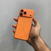 Rear panel view of a copper orange iPhone 17 Pro max non ptadisplaying the updated triple camera module and matte back glass.