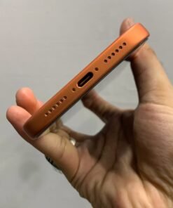 Bottom edge view of a copper orange iPhone 17 Pro max featuring the USB-C charging port and speaker grilles.