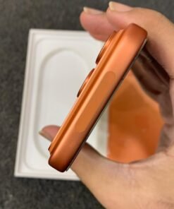 Angled top-edge view of a copper orange iPhone 17 Pro highlighting the extended camera island bump.