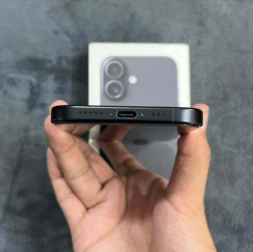 Bottom edge view of a Black iPhone 17 highlighting the USB-C charging port, dual speaker grilles, and bottom frame finish.