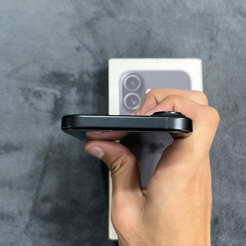 Top edge view of a Black iPhone 17 showing the smooth matte aluminum frame finish and camera bump offset.