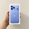 Front view of a concept iPhone 18 Pro retail box in light periwinkle blue held in hand against a neutral wall backdrop.
